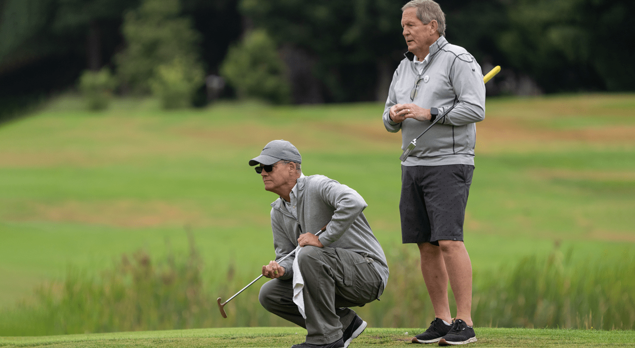 Archbishop Etienne and another man getting ready for a golf shot