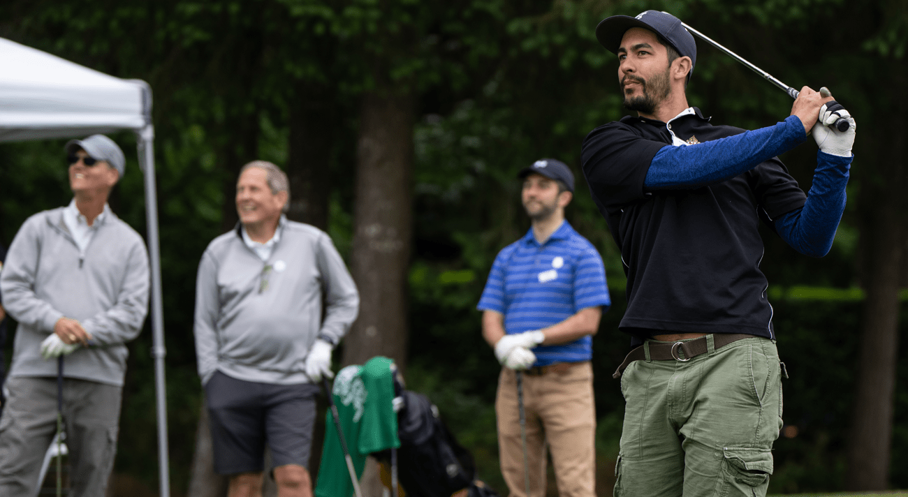 People watching a man swing a golf club