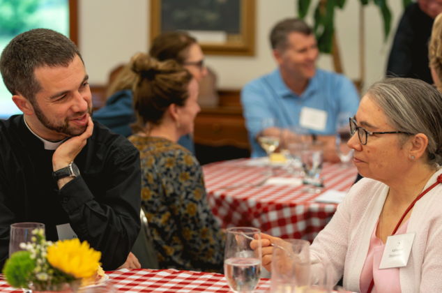 Father Ryan talking to a woman at the Crozier Society Barbeque