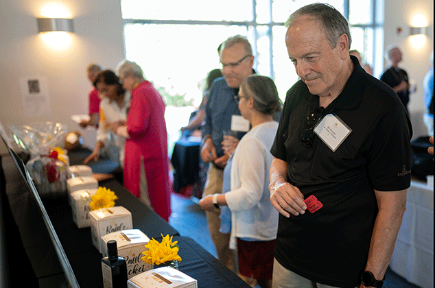People looking at auction items at the 2025 BBQ