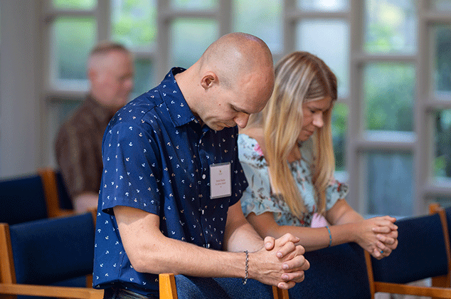 A husband and wife praying at the 2025 BBQ
