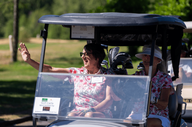 Women riding in a golf cart